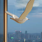 Close view of the pale wood seagull body, articulated wings, and suspension cords.