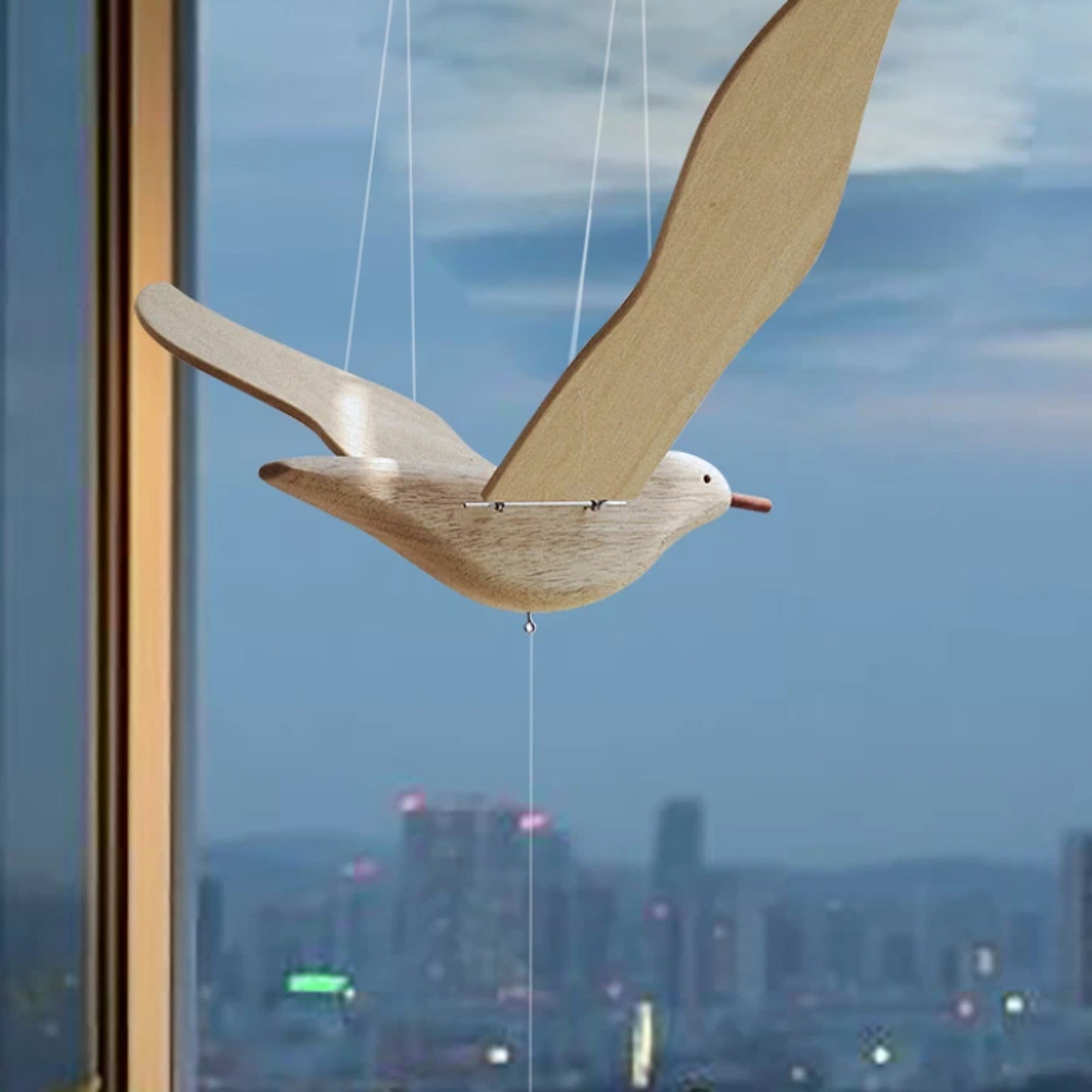 Close view of the pale wood seagull body, articulated wings, and suspension cords.